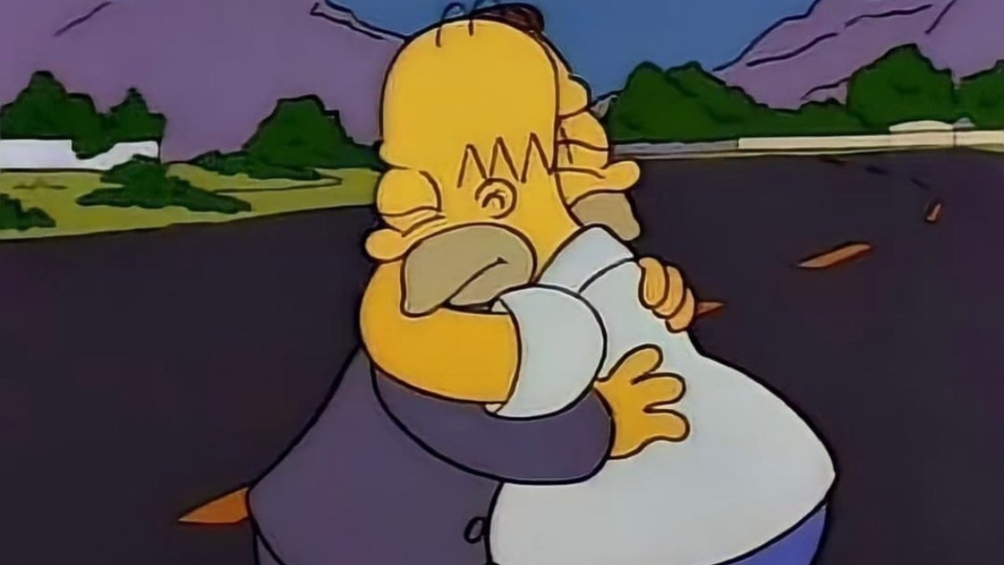Homero abraza a un hombre a media carretera