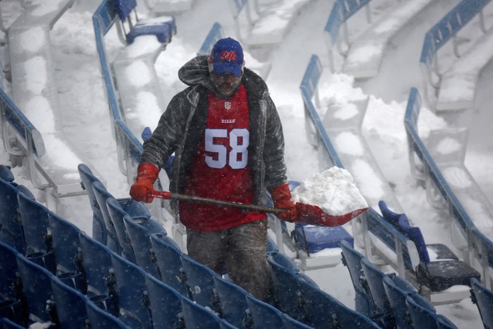 Un aficionado paleando nieve en el estadio de los Bills