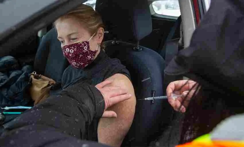 AP Persona siendo vacunada en su vehículo