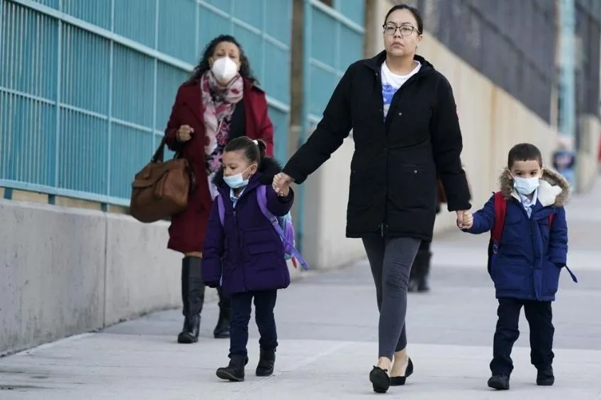 AP Mujer llevando a sus hijos a una escuela de Nueva York