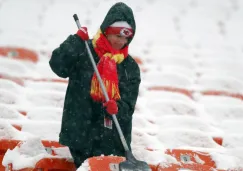 Una persona retira nieve de las gradas del Arrowhead Stadium