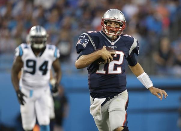 Tom Brady corre con el balón en un encuentro