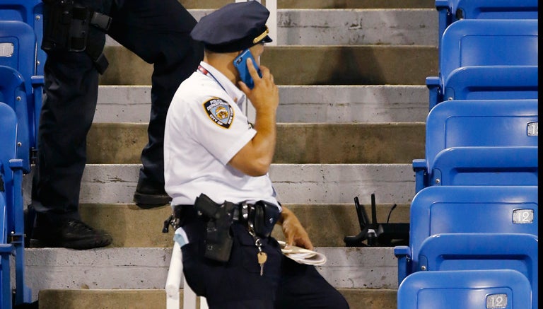 Policía observa el dron que se estrelló en las gradas del US Open