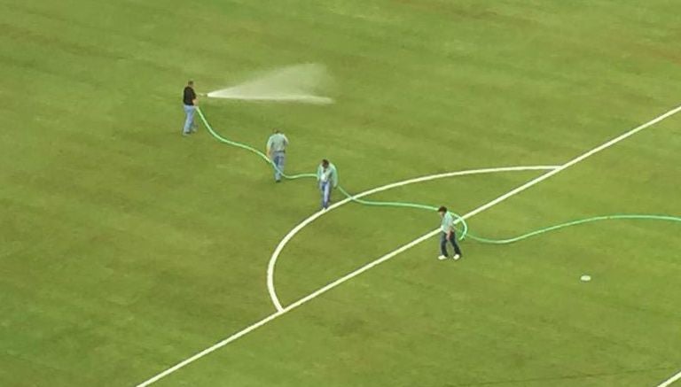 Trabajadores riegan la cancha del Estadio AT&T