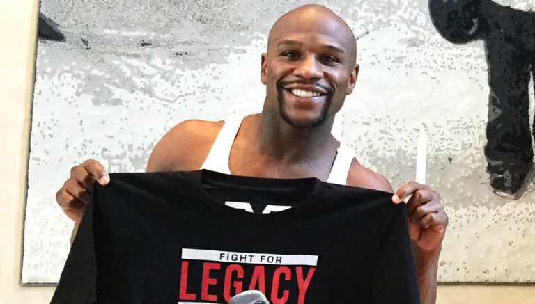 Floyd Mayweather posa con la playera que promociona su carrera