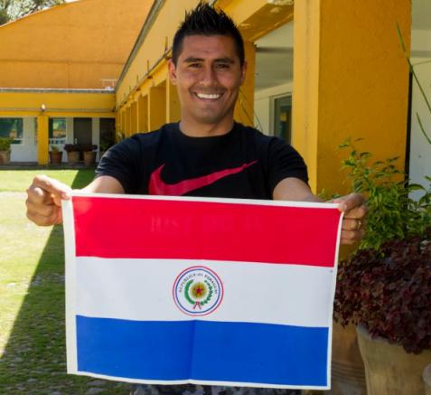 Martínez muestra una bandera de Paraguay