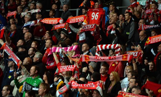 Seguidores del Liverpool levantan sus bufandas en Anfield