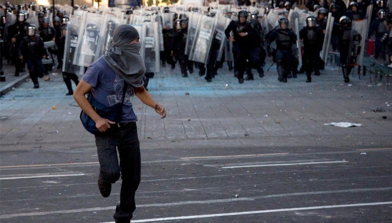 Policias tras manifestante en la marcha por el 2 de octubre