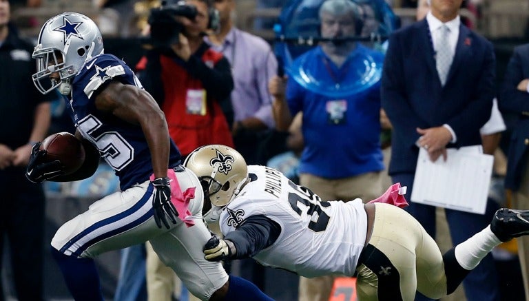 Lance Dunbar corre con el balón ante la tackleada de Kenny Phillips