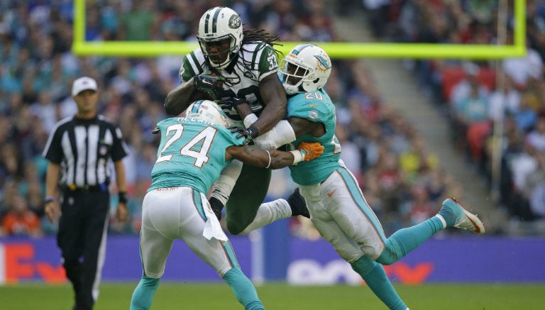 Chris Ivory entre dos defensivos de Miami