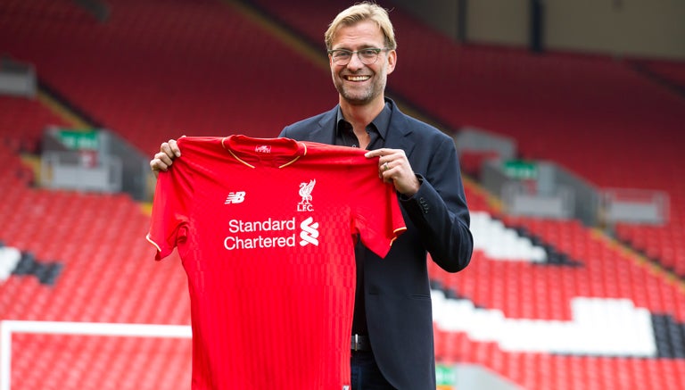 Klopp sostiene la playera de su nuevo equipo, el Liverpool