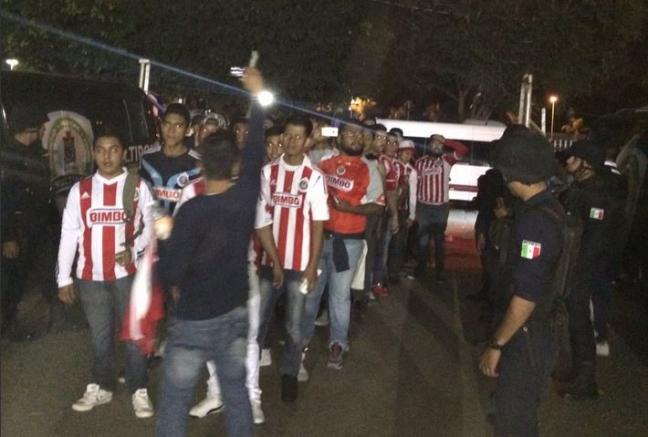 Algunos aficionados de Chivas entran al estadio