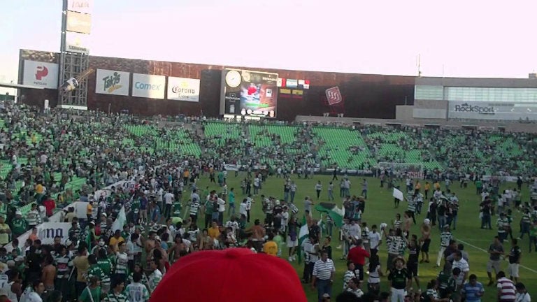 Aficionados corriendo a resguardarse en el Estadio Corona