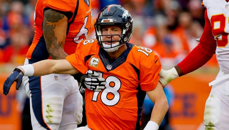 Manning es ayudado por jugadores para incorporarse