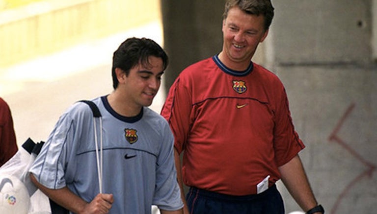 Xavi camina junto a Van Gaal 