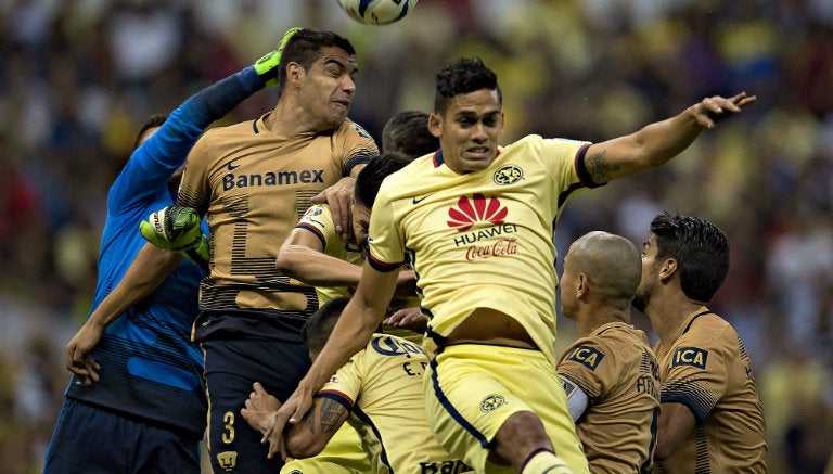 Jugadores de América y Pumas buscan un balón aéreo