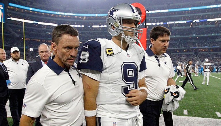 Tony Romo, siendo escoltado fuera del AT&T Stadium