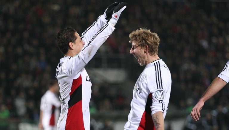 Chicharito se abraza con Kiessling tras anotar en la DFB Pokal