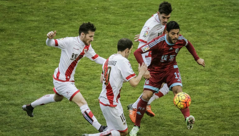 Carlos Vela, entre tres jugadores del Rayo Vallecano