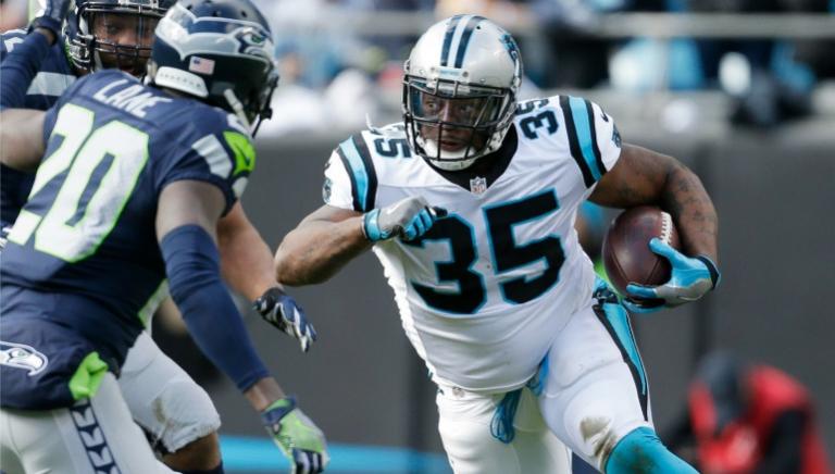 Mike Tolbert protege el ovoide en enfrentamiento contra Seattle