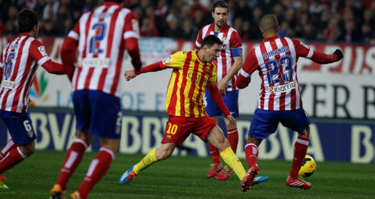 Messi controla el balón entre varios jugadores del Atlético