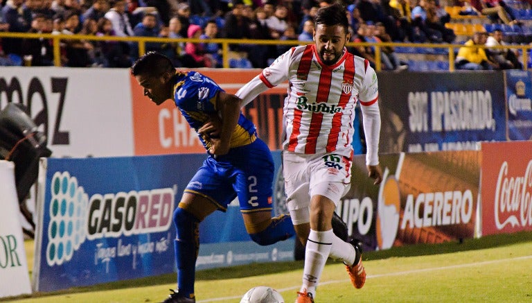 Juan Castro y Luis Gallegos pelean por el balón