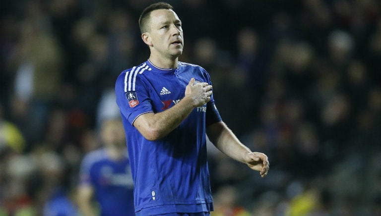 John Terry toca el escudo del Chelsea, viendo hacia la tribuna