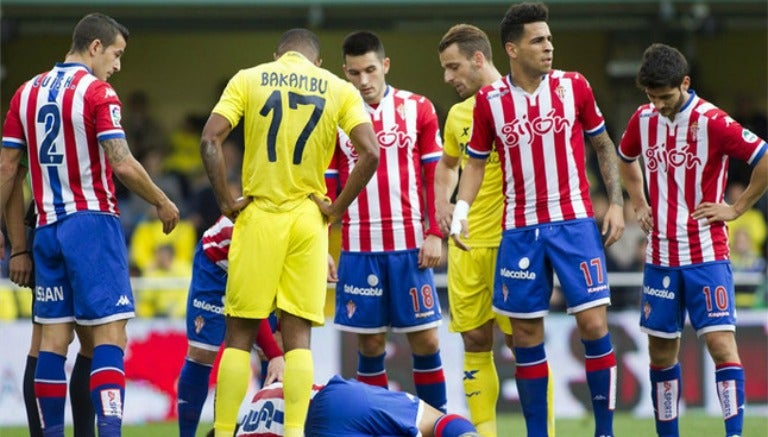 Jugadores del Gijón observan a uno de sus compañeros en el suelo