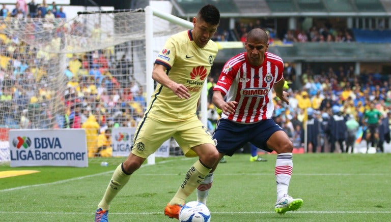 Oribe Peralta protege el balón de Carlos Salcido