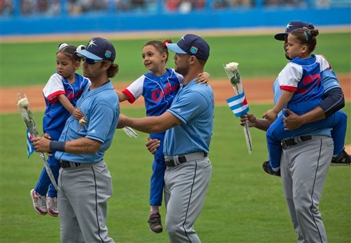 Jugadores de Rays cargan niños y flores previo al partido contra Cuba