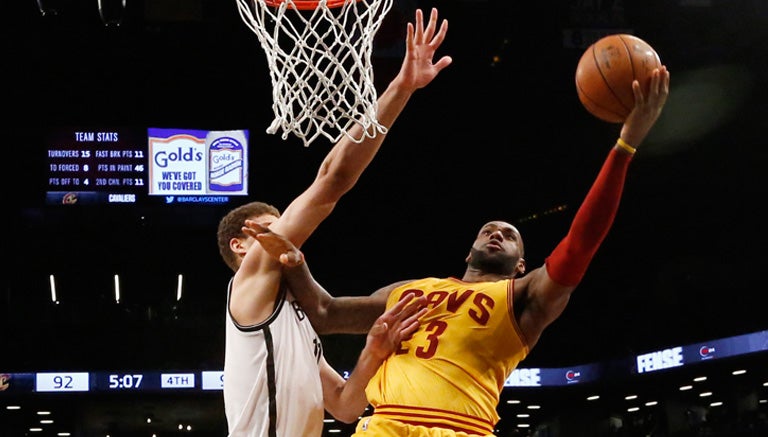 LeBron James intenta encestar ante la marca de Brook Lopez