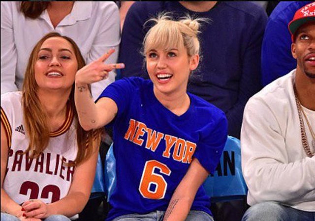 Miley Cyrus saluda en juego de basquetbol 