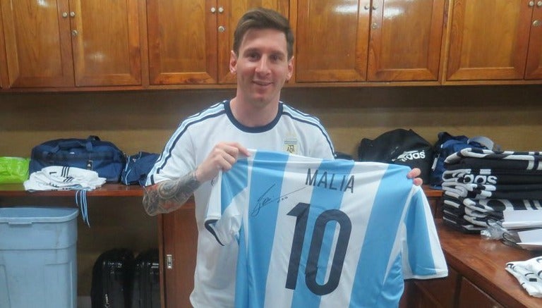 Lionel Messi sostiene una de las playeras que obsequió a la familia Obama