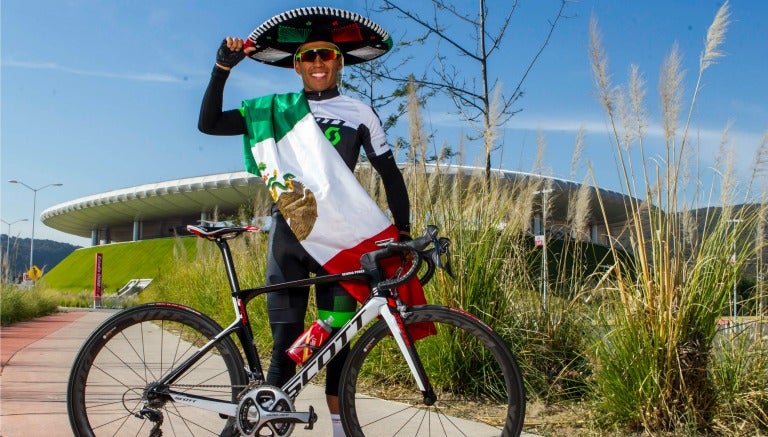 Irving Pérez posa junto con su bicicleta a las afueras del Estadio Chivas