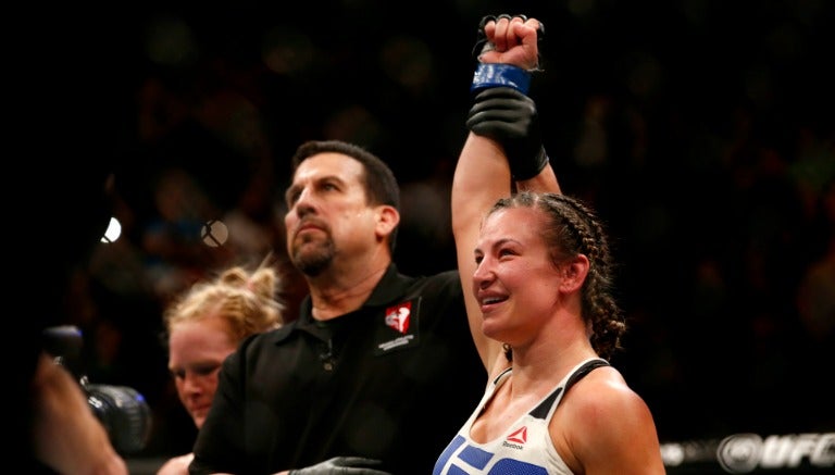 El referee levanta la mano de Miesha Tate tras ganar a Holly Holm