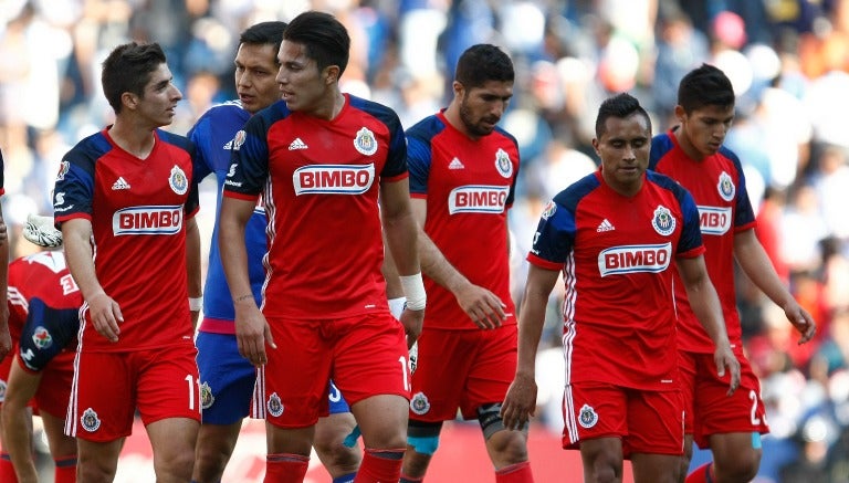 Jugadores de Chivas conversan antes de salir del campo