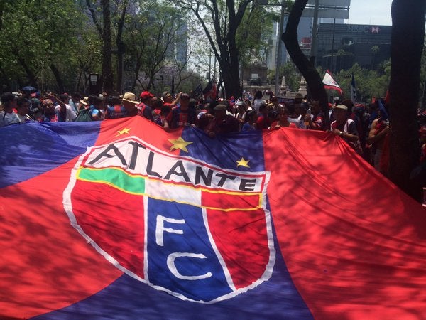 Aficionados muestran una bandera de su equipo