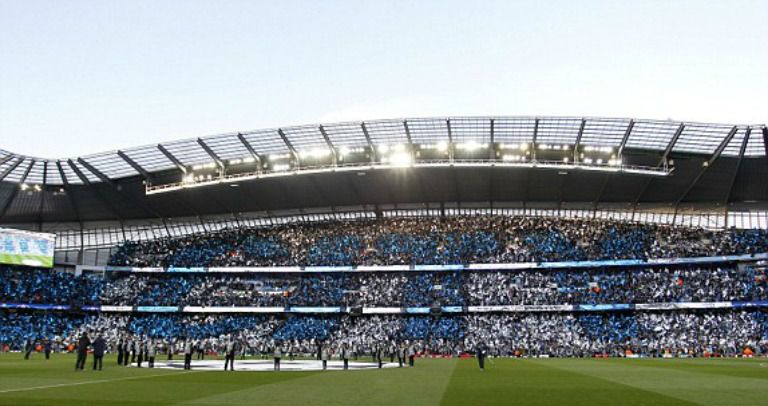 Aficionados muestran las banderas con los colores del City