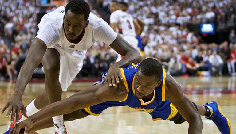 Al-Farouq Aminu, de Portland, y Harrison Barnes, de Golden State, luchan por la pelota