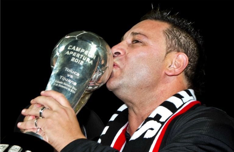 Antonio Mohamed besa el trofeo conseguido con Tijuana