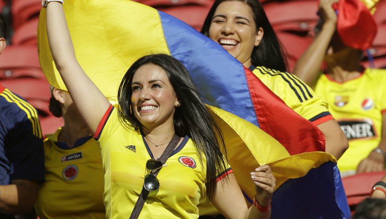 Una bella aficionada posa con la bandera de Colombia