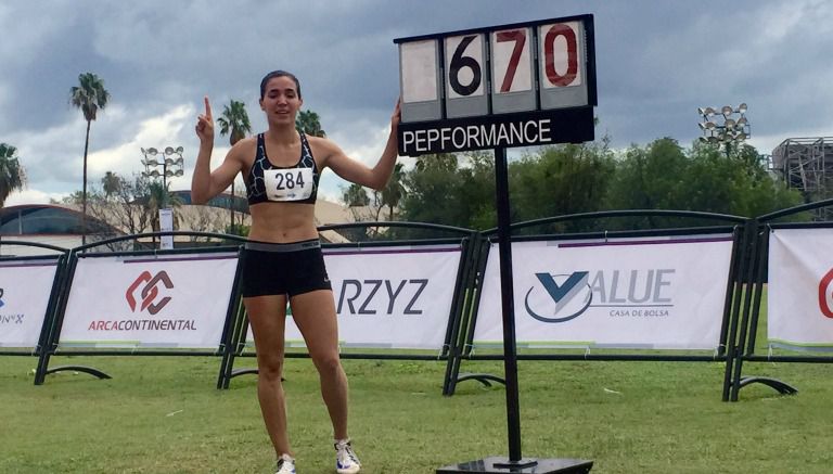 Yvonne Treviño posa al lado de la marca que impuso en el Campeonato Nacional de Atletismo