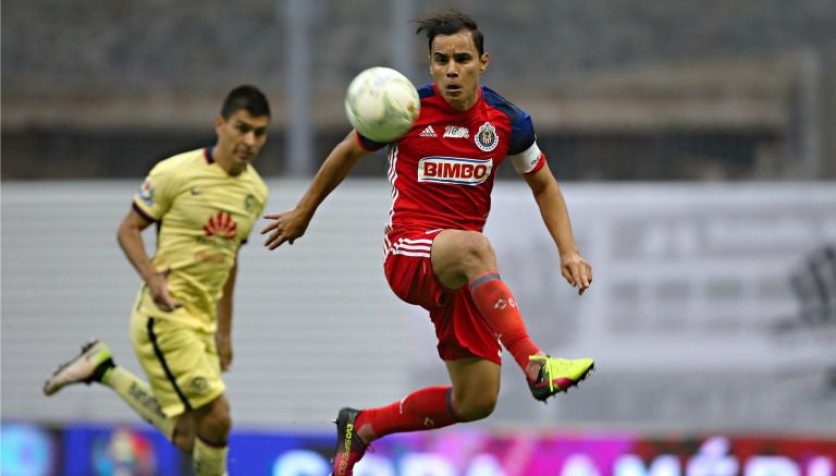 Omar Bravo controla el balón durante un partido contra el América