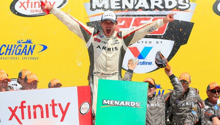 El piloto mexicano, Daniel Suárez, celebra su victoria en el podio de la NASCAR