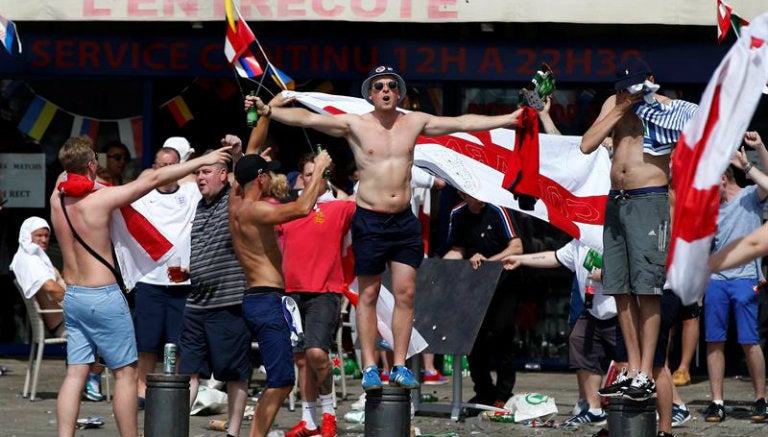 Un hooligan posa justo frente a una bandera inglesa