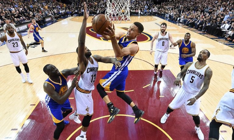 Stephen Curry avanza hacia la canasta de los Cavaliers