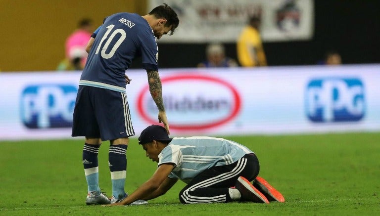 Un joven haciéndole reverencias a Lionel Messi