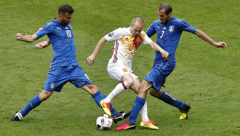 Iniesta cubre el balón en juego contra Italia