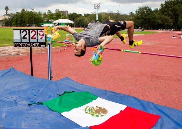 Edgar saltando la vaya sobre la bandera de México