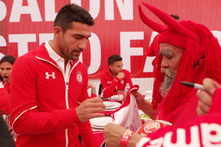 Sinha firma autógrafo a aficionado de Toluca